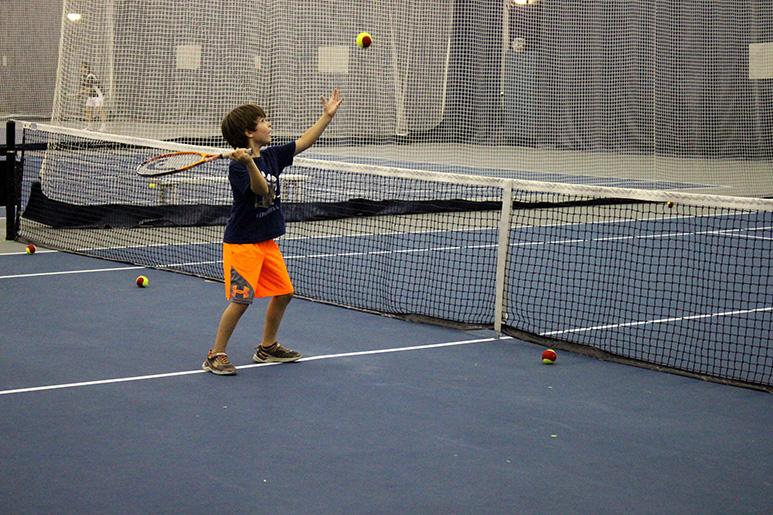 Child hitting a tennis ball